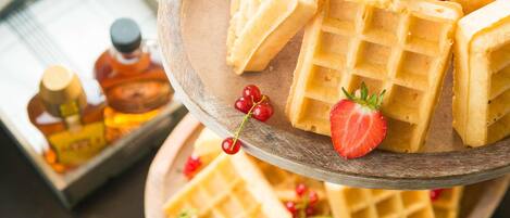 A wooden tray with waffles and strawberries.