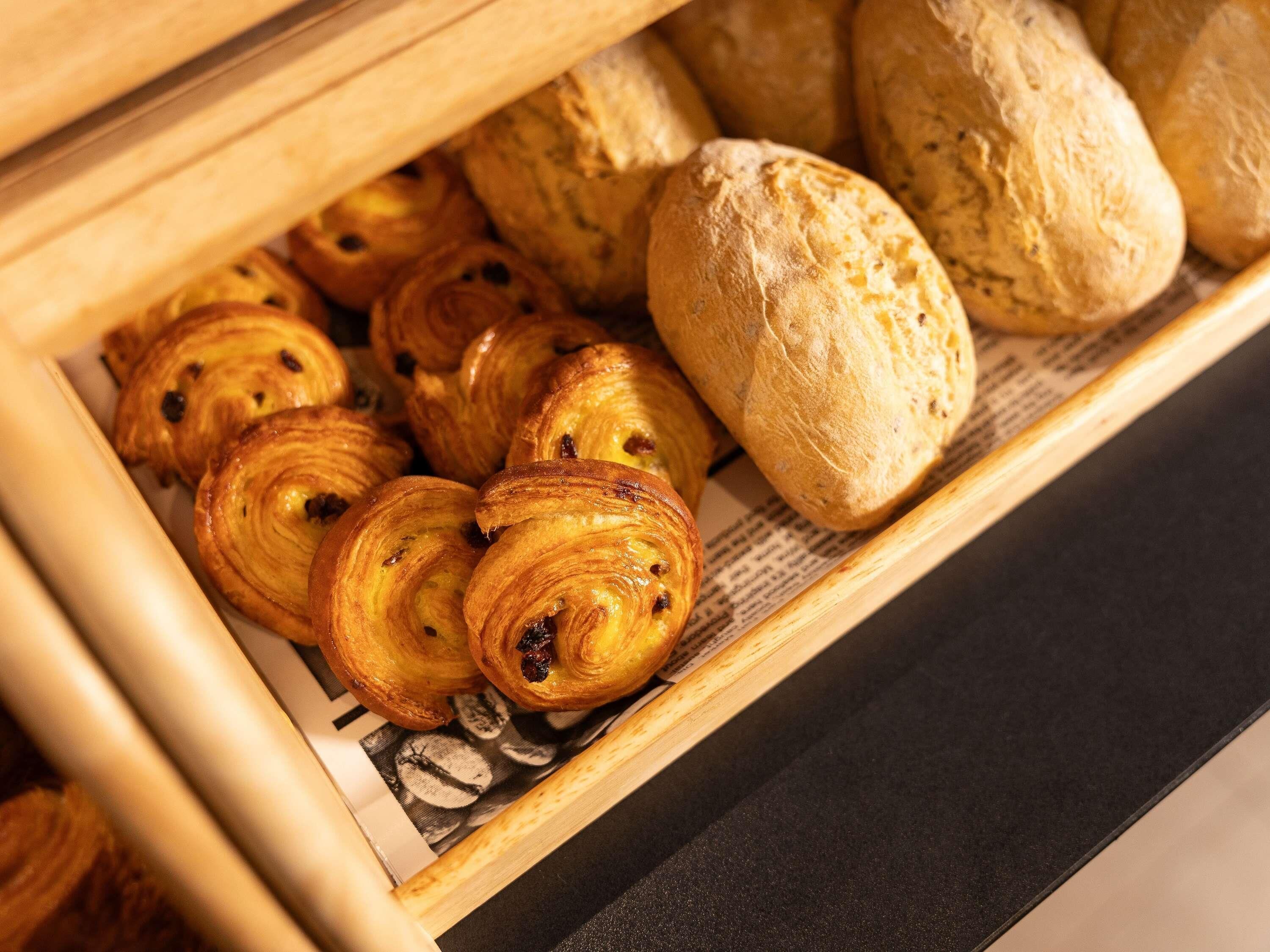 A bakery display case with various pastries, including croissants and scones.