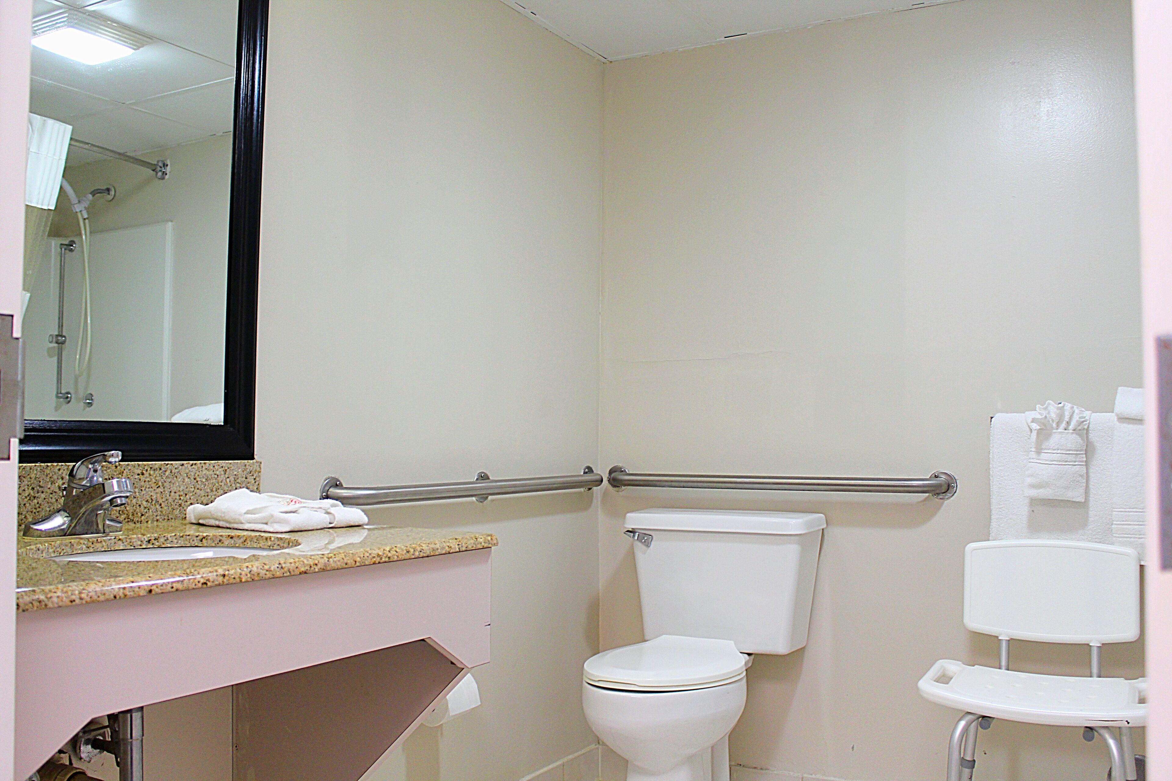 Un baño con lavamanos, inodoro y zona de ducha.