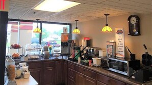 A cafe with a counter, coffee machines, and a clock on the wall. - Baymont by Wyndham Springfield (Springfield)