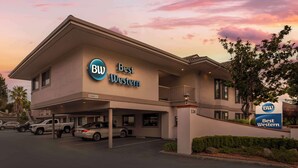 A Best Western hotel with a clear view of the entrance, parking area, and a sign indicating the hotel's name. - Best Western Inn (Santa Cruz)