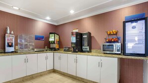 A hotel kitchen with a microwave, coffee machine, and a refrigerator. - Best Western Inn (Santa Cruz)