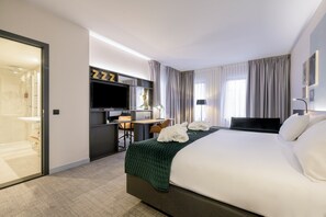 A hotel room with a bed, a desk, a TV, and a bathroom. - Holiday Inn Hasselt by IHG (Hasselt)