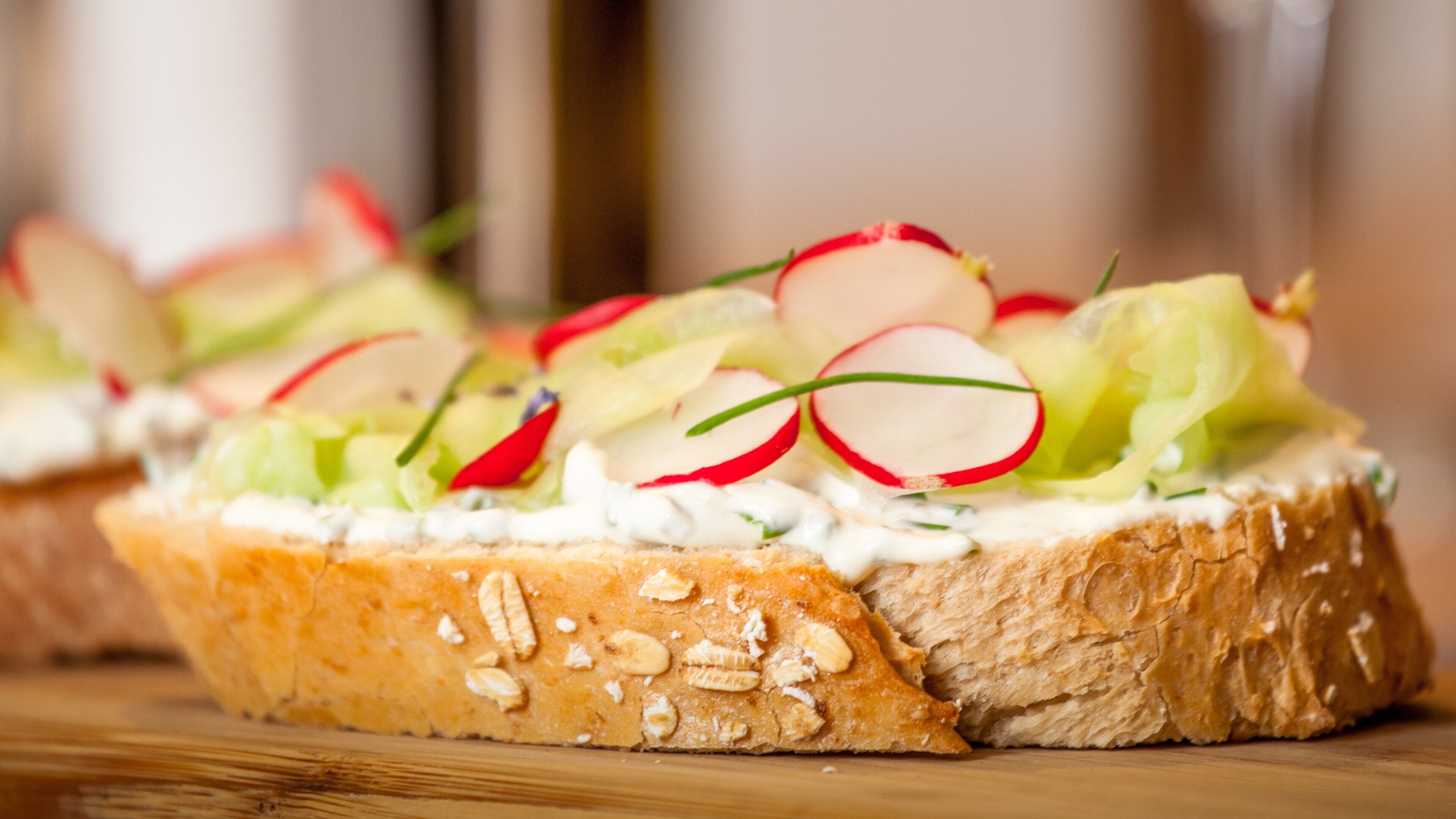 Un sándwich con diferentes ingredientes sobre una tabla de madera.