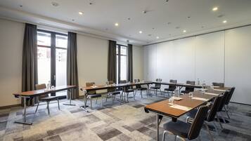 A conference room with a long table, chairs, and a carpeted floor.