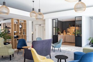 Un vestíbulo moderno con asientos, una estantería de madera y una zona de cocina.