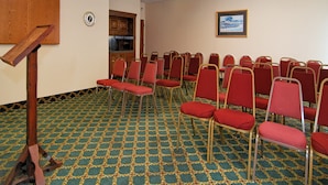 A conference room with rows of red chairs, a wooden podium, and a patterned carpet. - Red Roof Inn Nashville - Music City (Nashville)