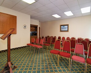 A conference room with rows of red chairs, a wooden podium, and a patterned carpet. - Red Roof Inn Nashville - Music City (Nashville)