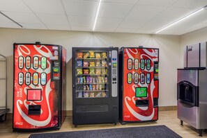 Three vending machines with various snacks and drinks, a Coca-Cola branded machine, and a water dispenser. - Red Roof Inn Nashville - Music City (Nashville)