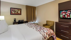 A hotel room with a bed, a desk, a chair, a television, and a dresser. - Red Roof Inn Nashville - Music City (Nashville)