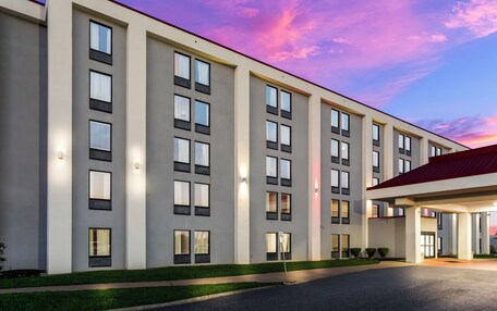 A modern hotel building with multiple floors, large windows, and a well-lit entrance.
