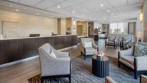A hotel lobby with a reception desk, seating area, and a view of the city. - Best Western River North Hotel (Chicago)