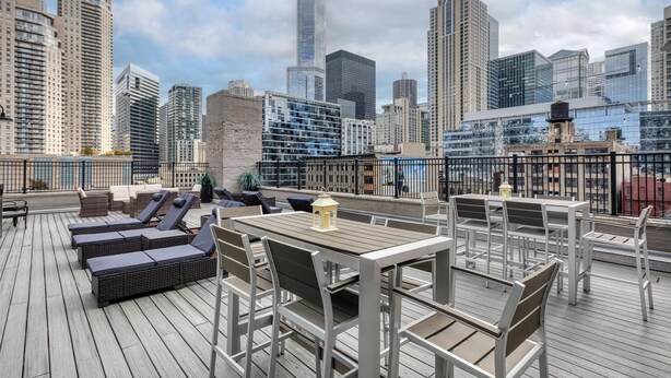 A rooftop terrace with lounge chairs and tables, offering a city skyline view. - Best Western River North Hotel (Chicago)