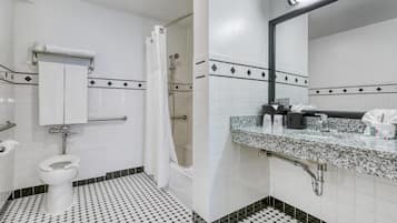 A bathroom with a toilet, shower, and sink.