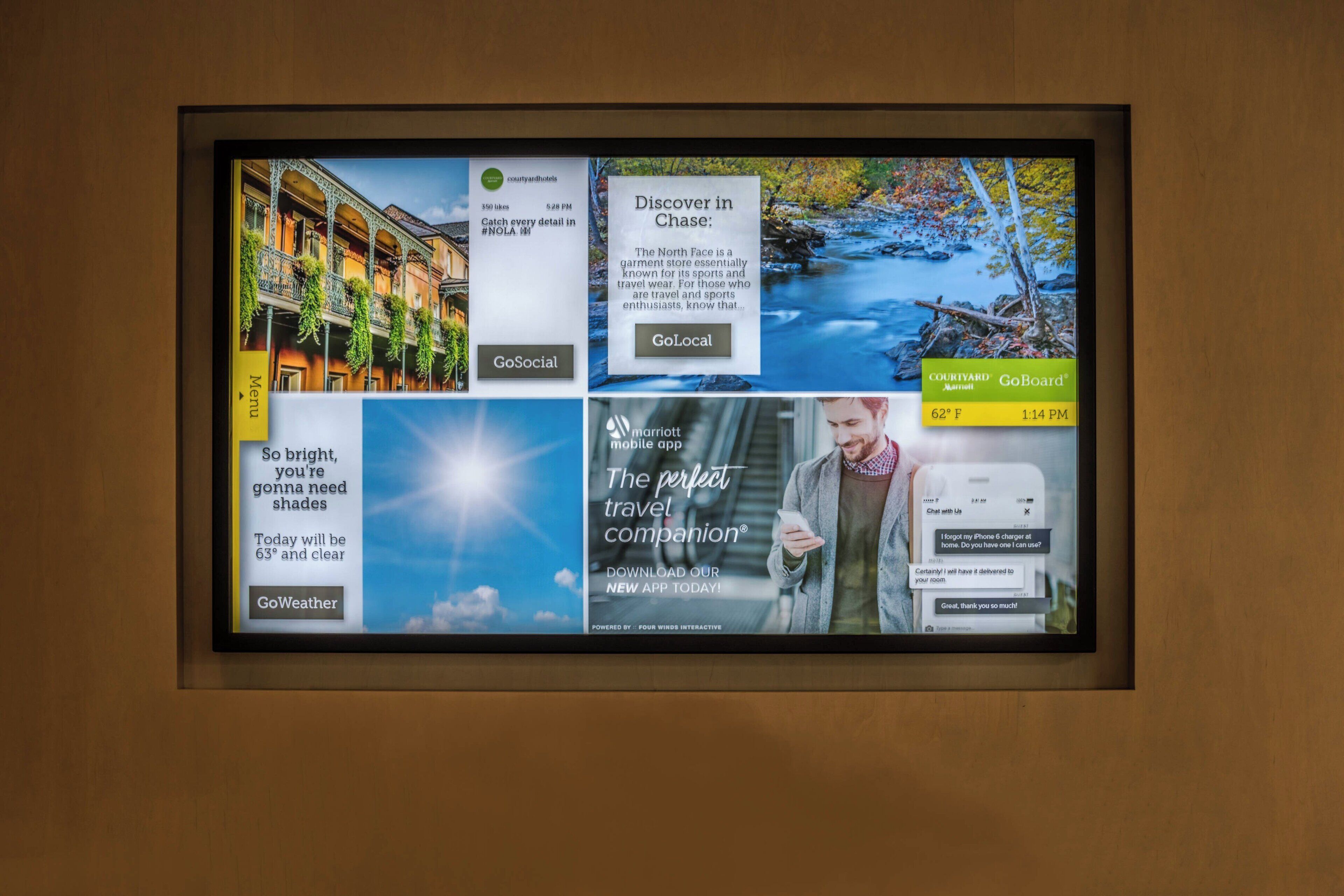 A digital display with various travel-related advertisements and information.