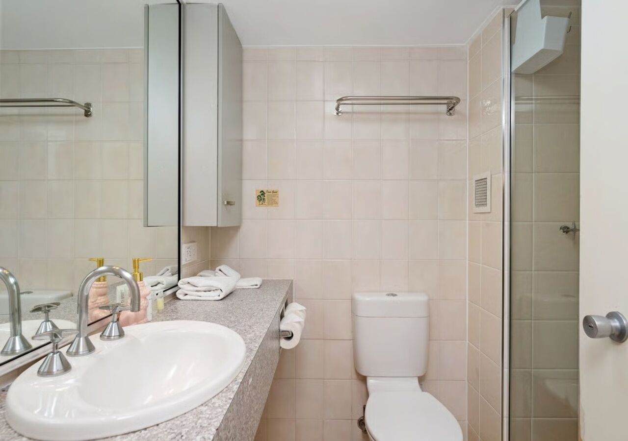 A bathroom with a sink, toilet, and shower.