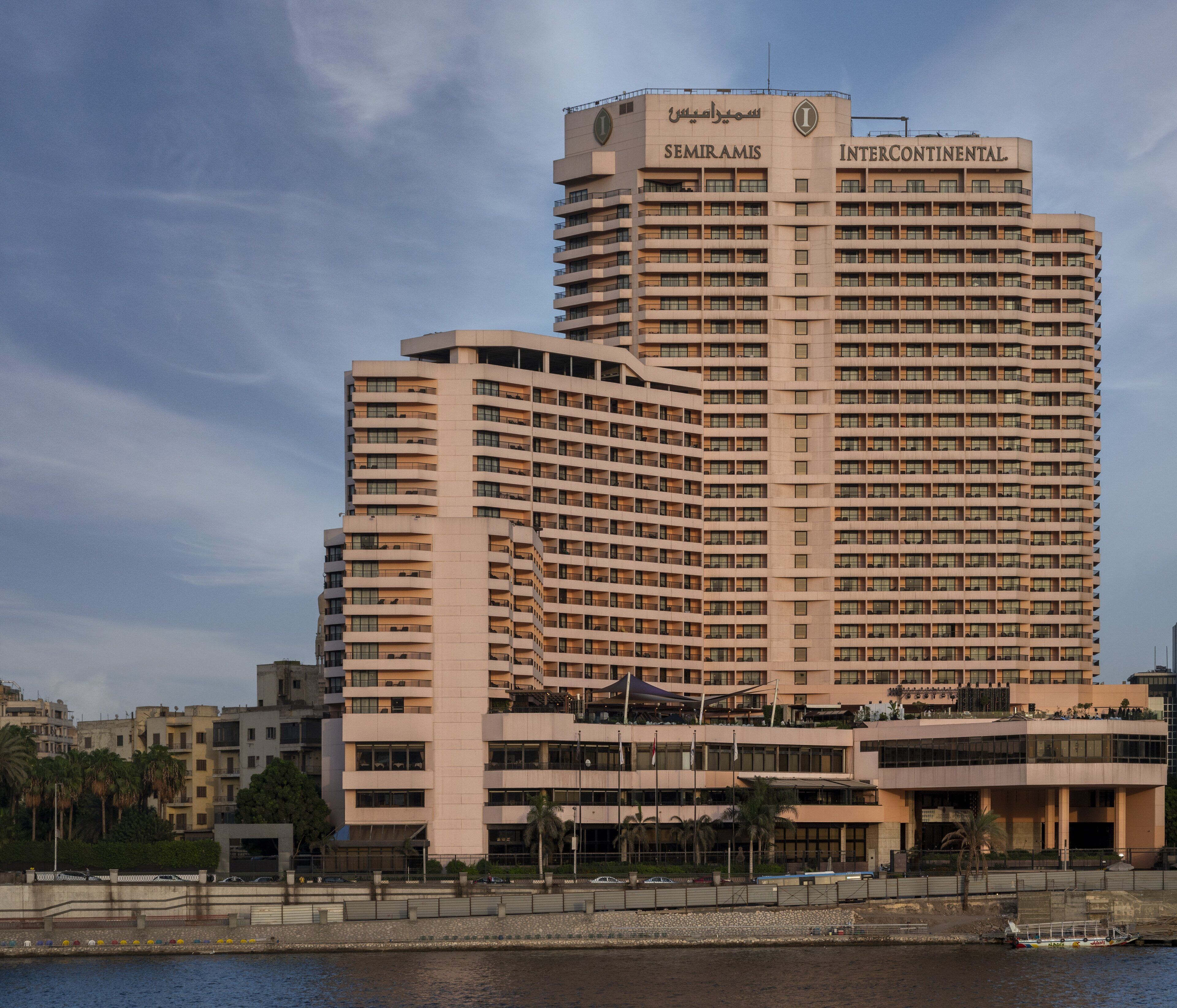 A large, multi-story hotel with a modern design, featuring balconies and a prominent signage for 'EMIRAMIS' and 'INTERCONTINENTAL'.