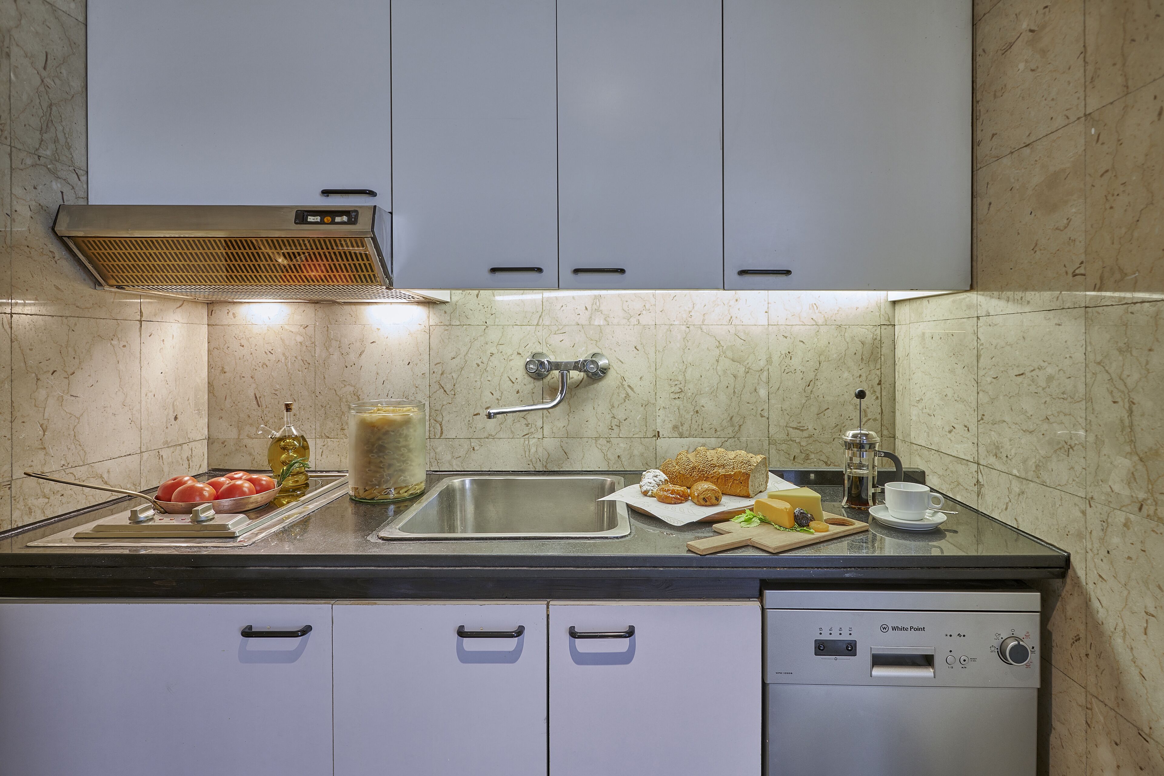 A modern kitchen with a stainless steel sink, a built-in oven, and a dishwasher.