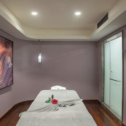 Relax in this serene spa room with a large bed, marble sink, and a touch of elegance.