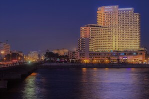 A high-rise hotel with multiple floors, a prominent sign at the top, and a waterfront view.