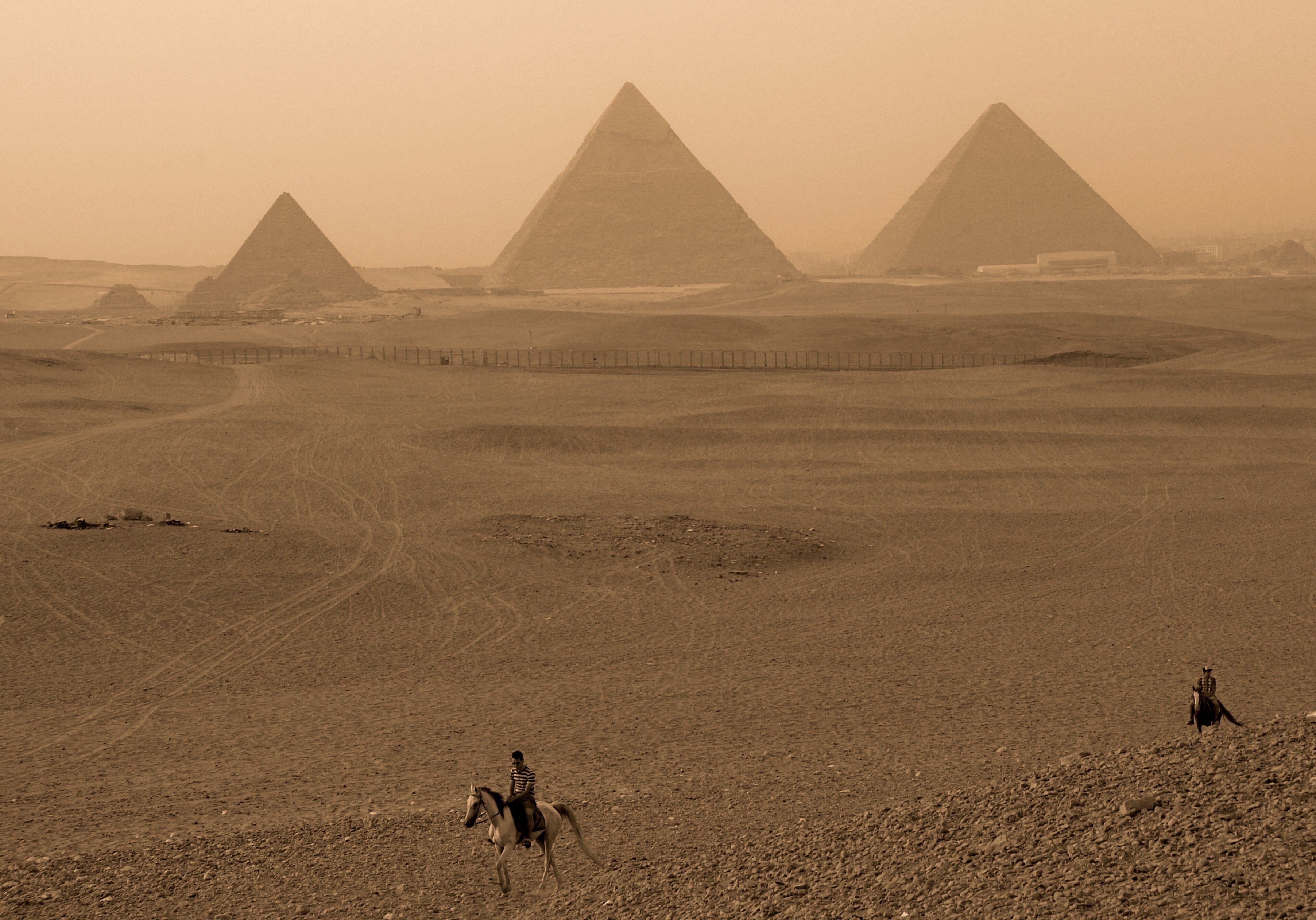 A desert landscape with pyramids in the background.