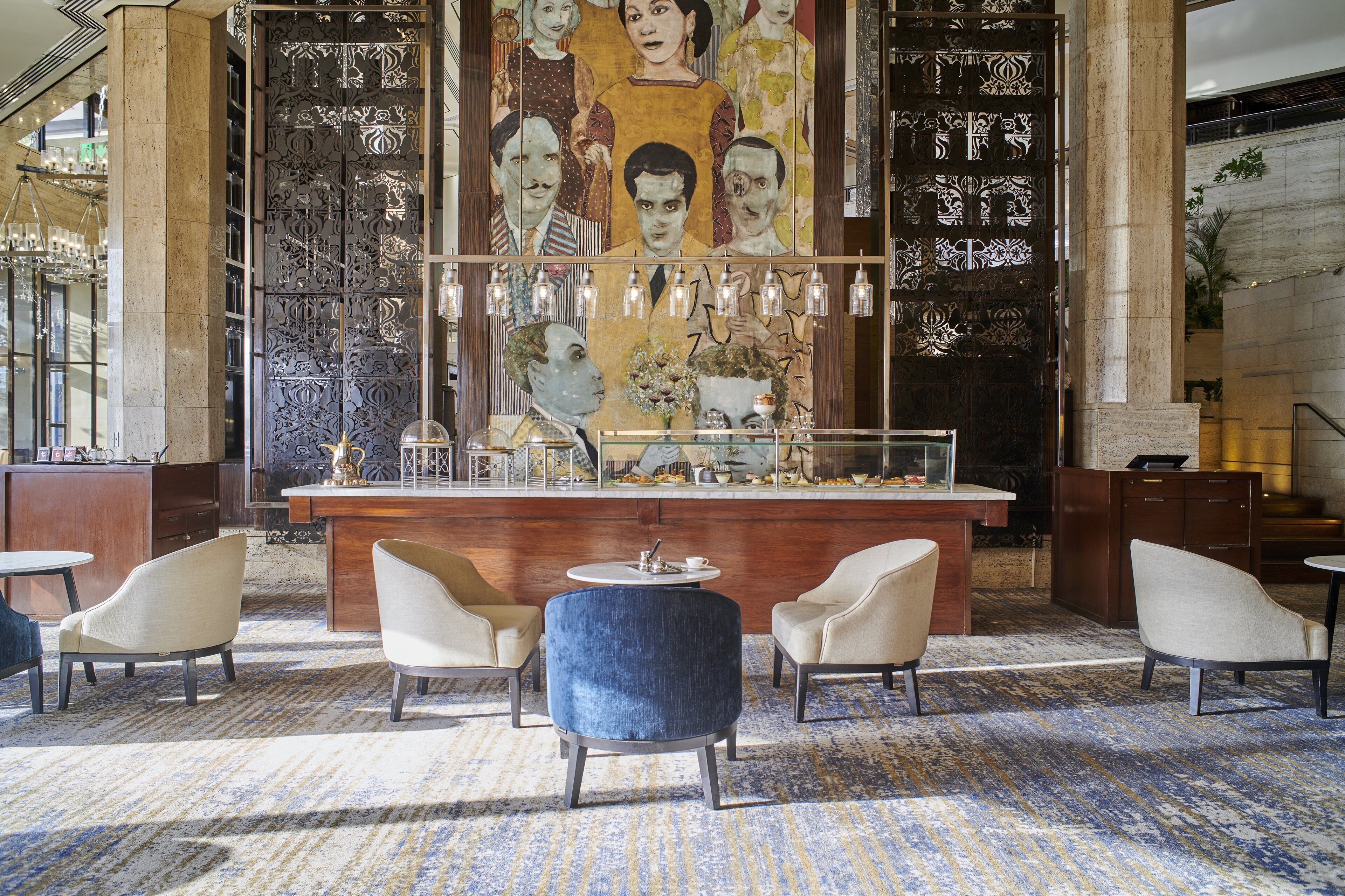 A lobby with a bar area, seating, and a large decorative wall.