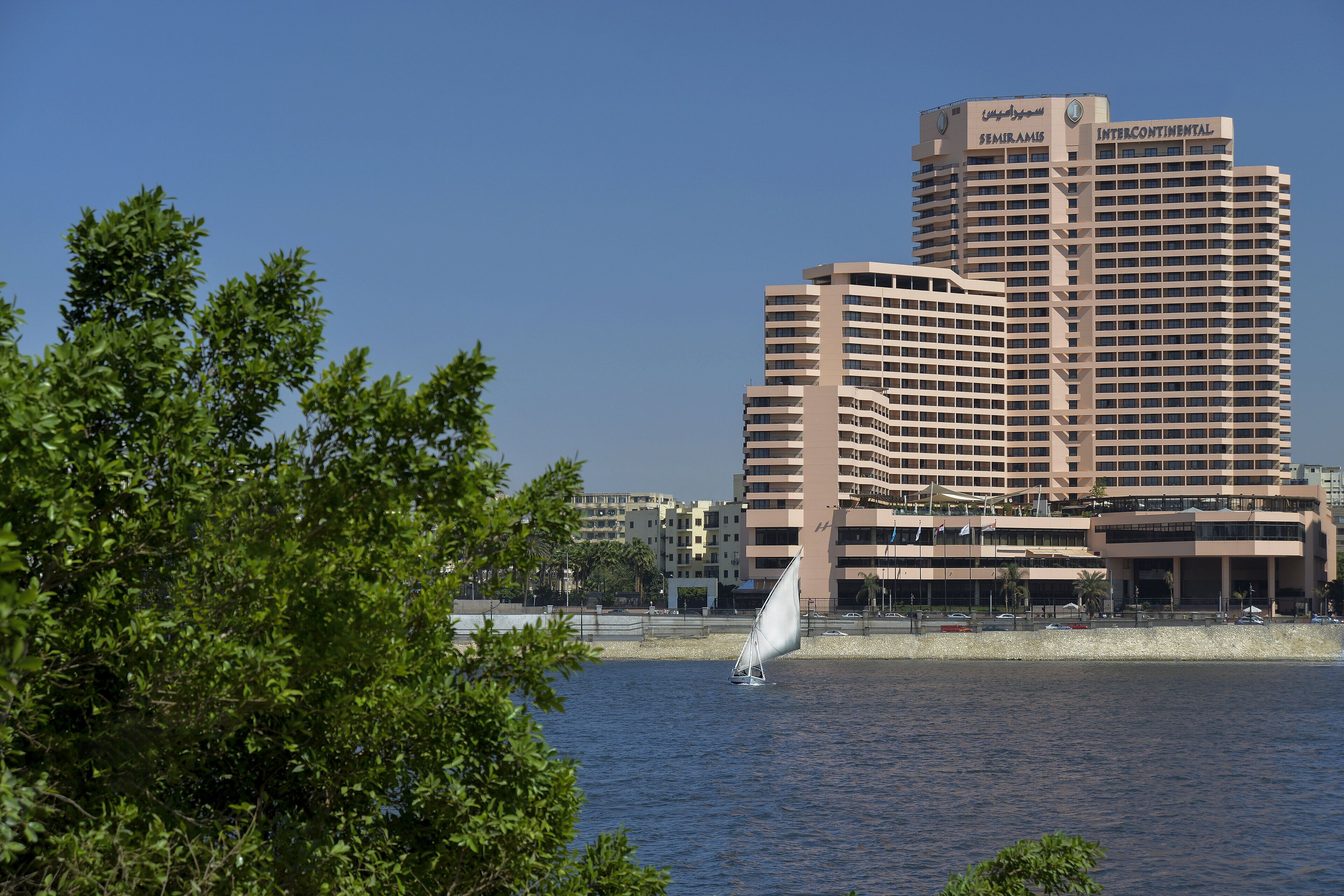 Un hôtel de grande hauteur doté de nombreux balcons et d’un élément décoratif aquatique bien visible au premier plan.