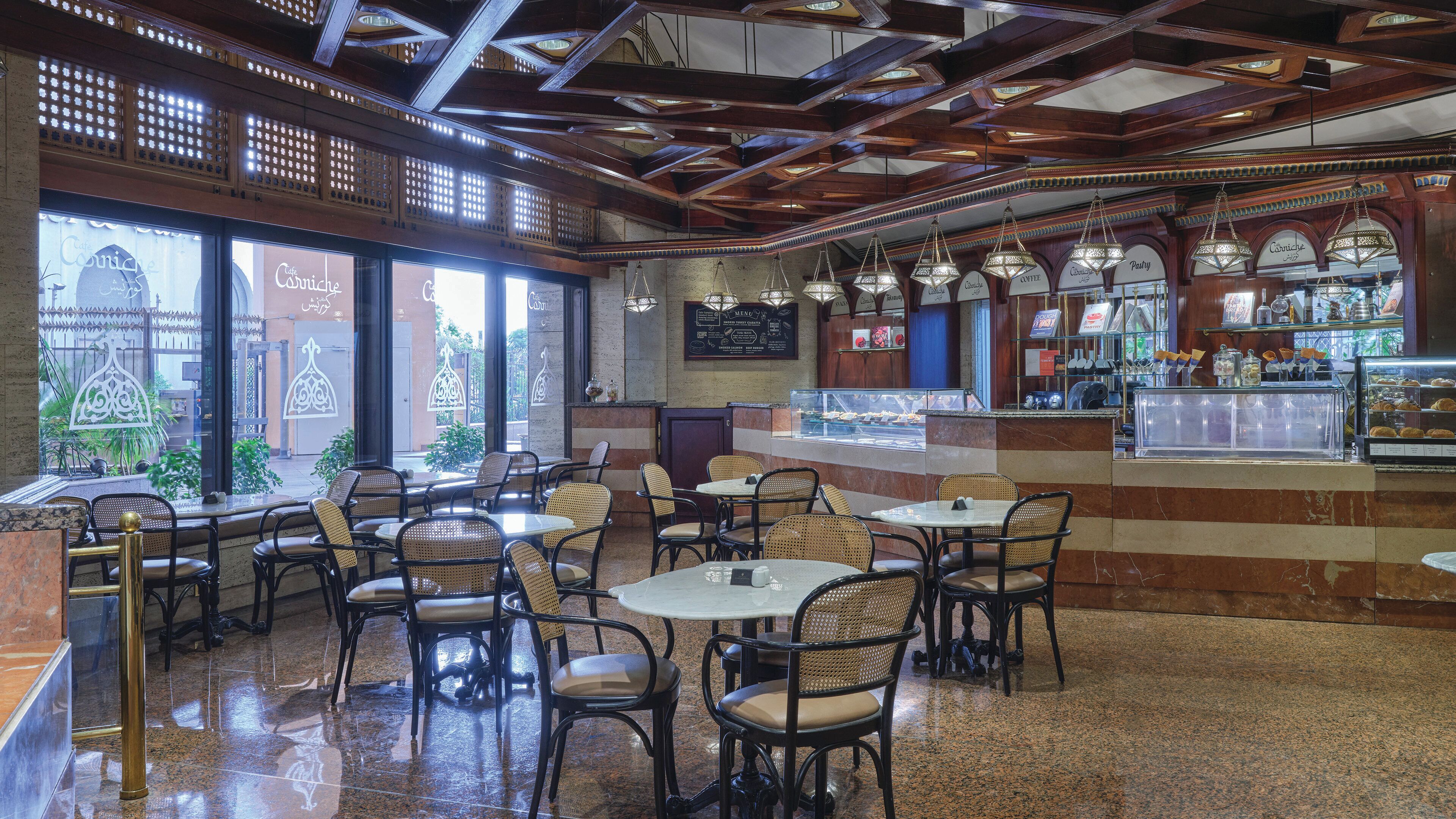 A cafe with multiple seating areas, a coffee bar, and a menu board.