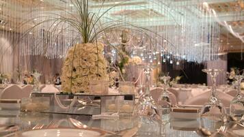 A formal dining setting with glassware, white roses, and elegant table settings.