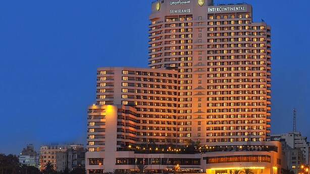 Un hôtel de grande hauteur, avec de nombreux étages, une enseigne bien visible et une vue sur le front de mer.