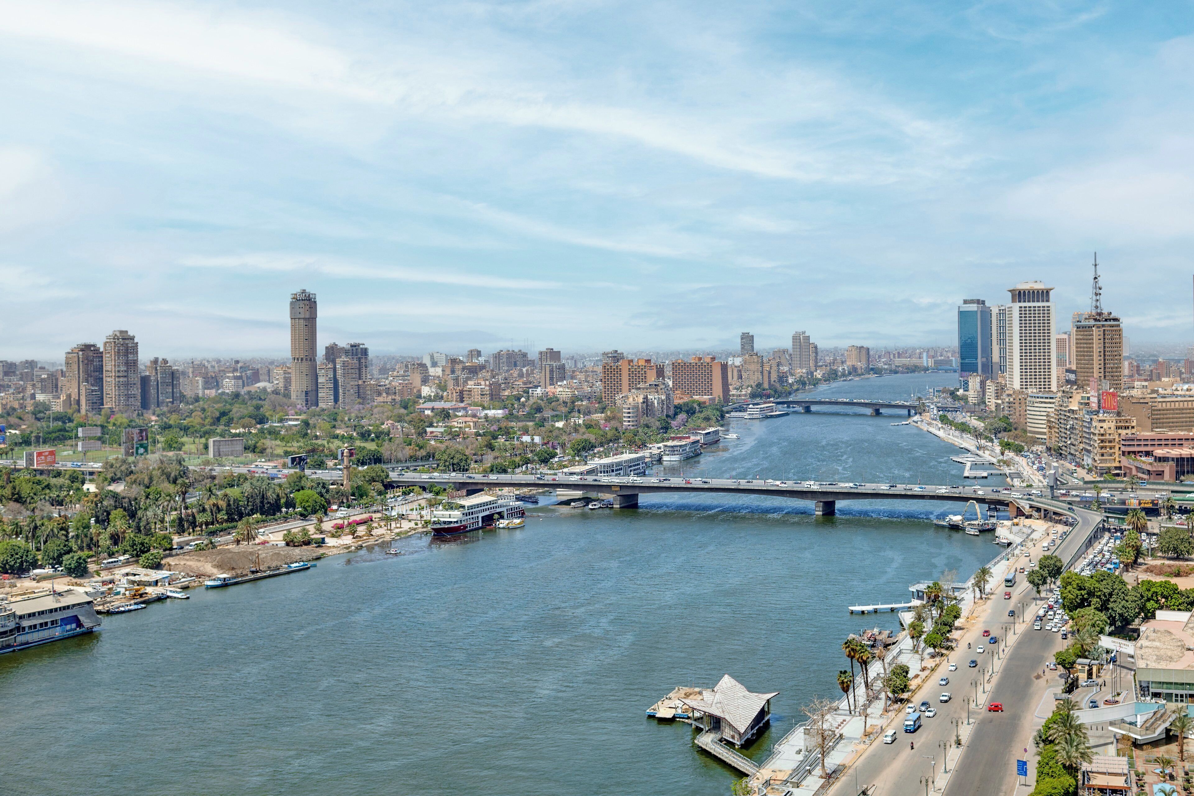 Un río con un puente, el horizonte de la ciudad y barcos.