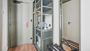 A compact hotel room with a built-in wardrobe, a small kitchenette, and a wooden floor. - D'win Hotel (Paris)