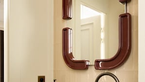A bathroom with a marble sink, a modern faucet, and a mirror with a unique frame design. - La Boetie (PARIS)