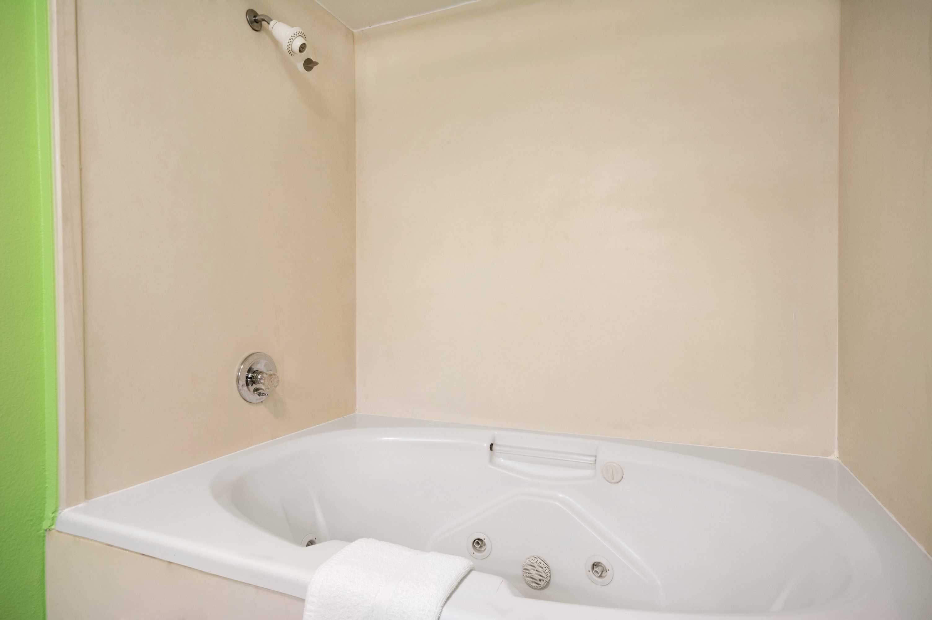 Una bañera blanca con ducha y una toalla.