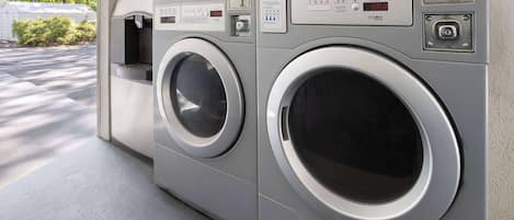 A row of front-loading washing machines in a commercial setting.