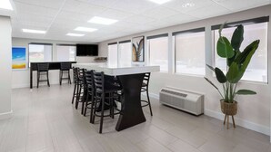 A modern office with a long table and chairs, large windows, and a potted plant. - Days Inn by Wyndham Acworth (Acworth)