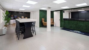 A modern office space with a reception area, a bar, and a seating area with chairs and a table. - Days Inn by Wyndham Acworth (Acworth)