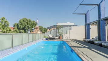 Een buitenzwembad, parasols voor strand/zwembad
