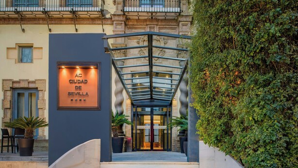 De ingang van een hotel met een bord waarop staat 'AC Ciudad de Sevilla'.