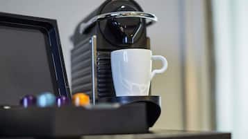 A coffee machine with a white cup on a tray.