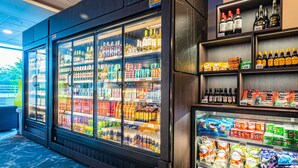 Balcão refrigerado com diversas bebidas e lanches.