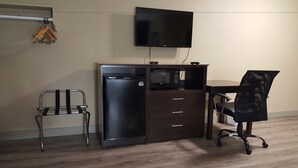 Un espacio de oficina compacto con escritorio, silla y refrigerador integrado.