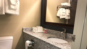 Un baño con inodoro, lavamanos y barra para toallas.