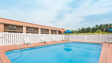 Una piscina al aire libre de temporada, sillones reclinables de piscina