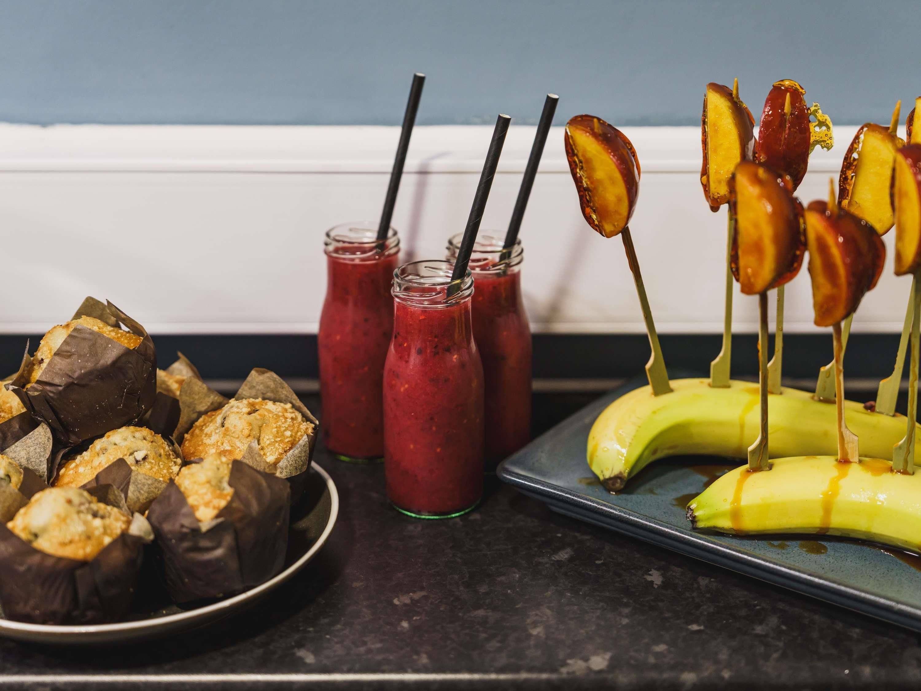 Una bandeja con alimentos, incluyendo pasteles, batidos y una banana con salsa de caramelo.