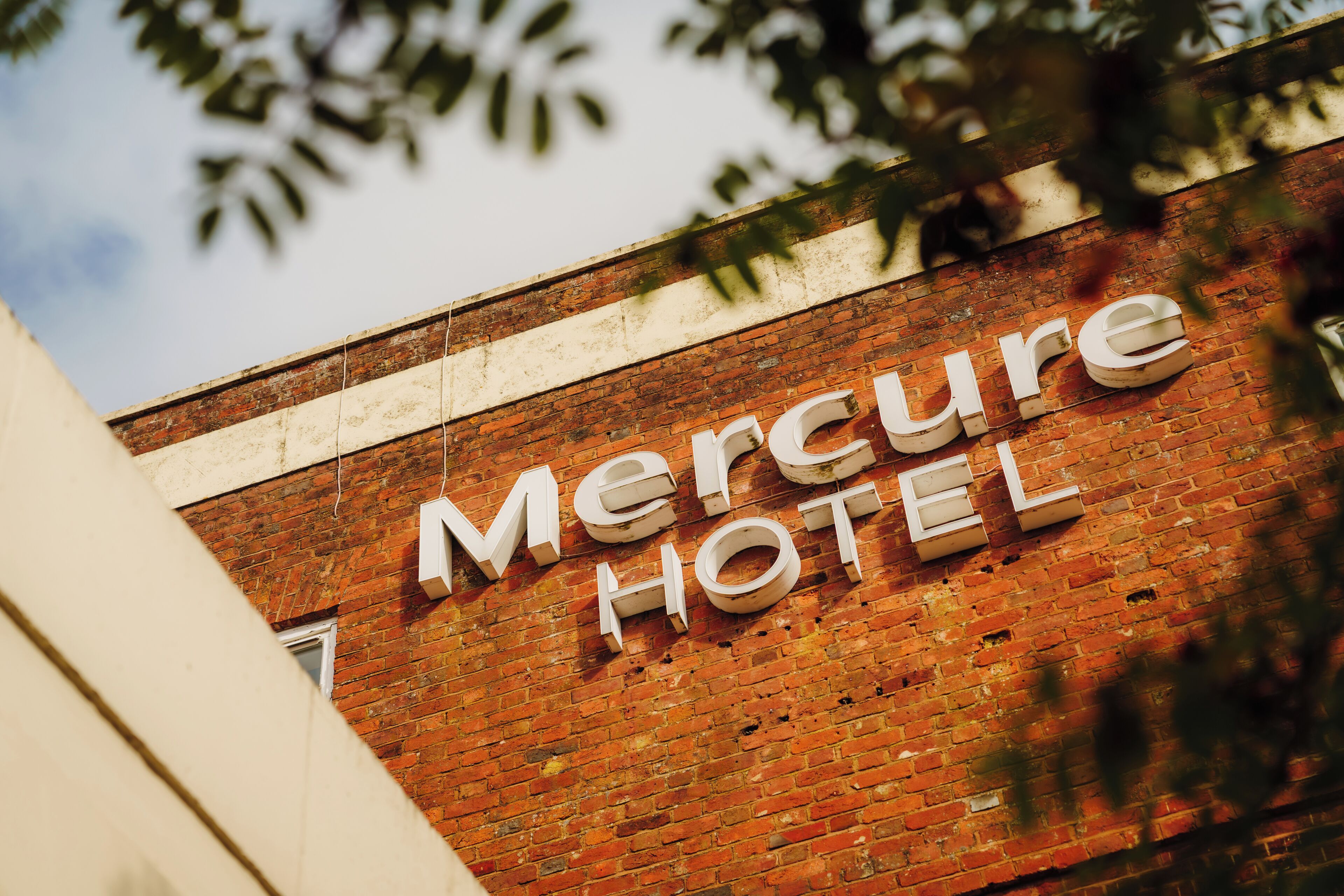 Un mur de briques sur lequel on peut lire en lettres blanches : « MERCURE HOTEL ».