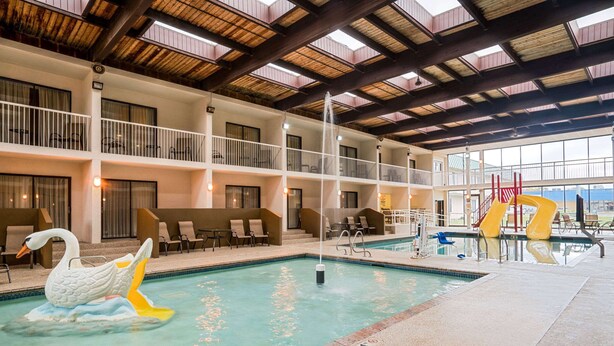 A hotel lobby with a large indoor pool, a swan float, and a slide. - Ramada Hotel & Conference Center by Wyndham Plymouth (Plymouth)
