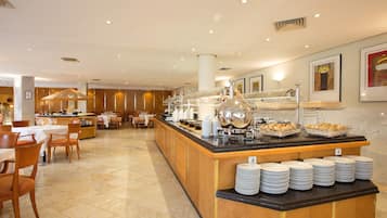 A buffet area with a marble floor, wooden chairs, and tables.