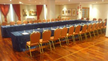 A conference room with a long table, chairs, and a fire extinguisher on the wall.