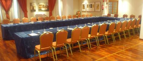 A conference room with a long table, chairs, and a fire extinguisher on the wall.
